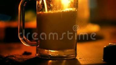 特写镜头，有人在休息室的酒吧里用温暖的烛光把一杯汽水倒进桌子上的玻璃杯里。